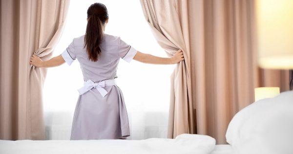 La camarera de un hotel de lujo en Polonia lava las cortinas sin quitarlas de las cornisas La camarera de un hotel de lujo en Polonia lava las cortinas sin quitarlas de las cornisas
