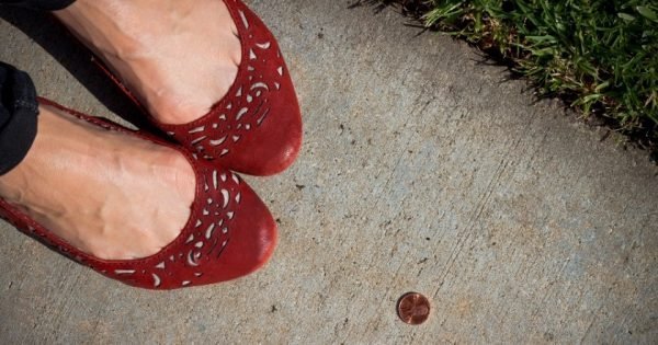 A girl in red shoes finds a penny on the sidewalk. Pick it up and you'll have good luck all day!
